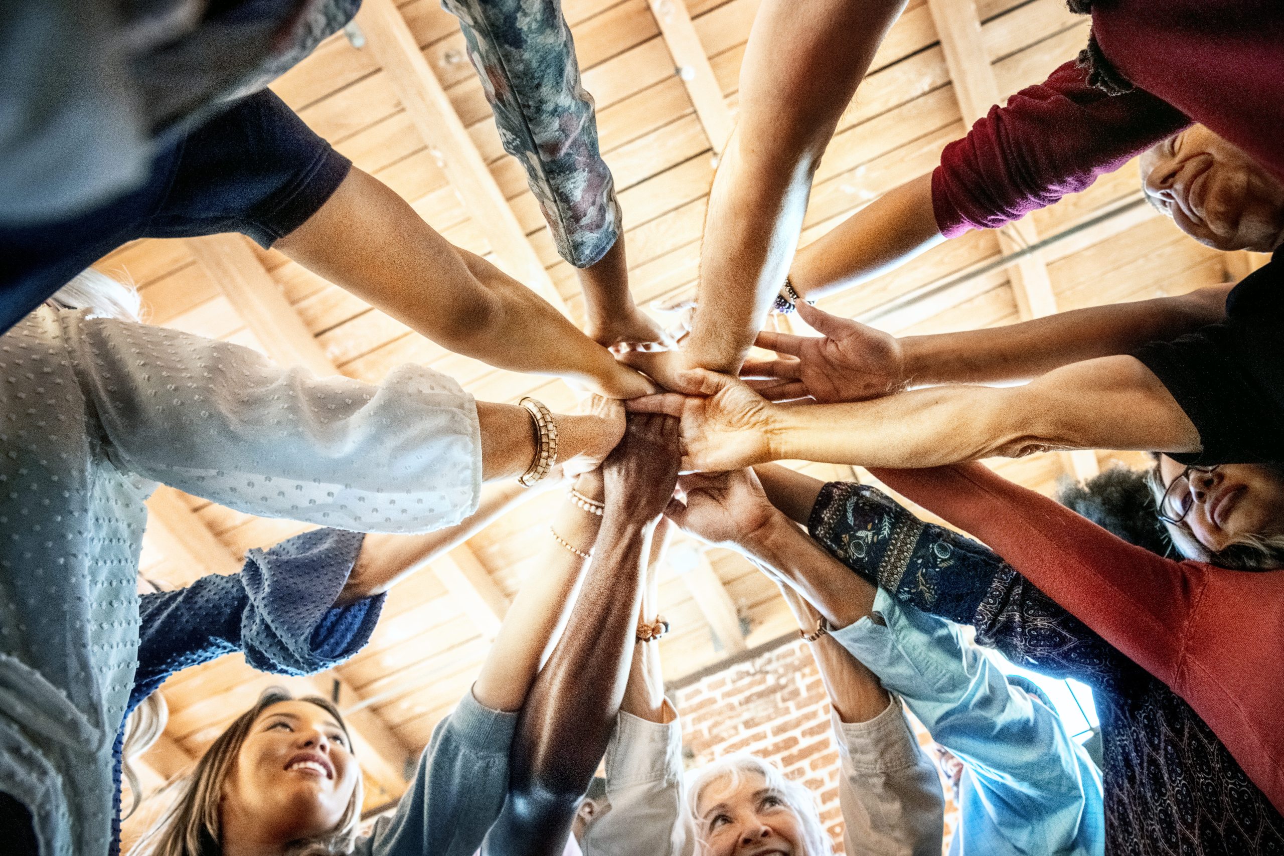 Food bank volunteer wearing a red polo shirt stood in front of food crates looking into the distance.